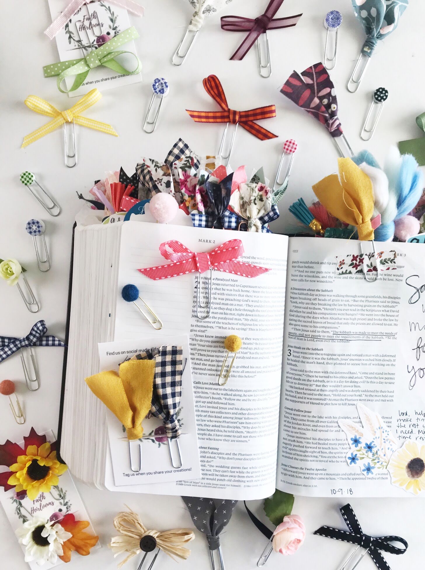 Open Bible with DIY Paper Clip book marks with bows, fabric, silk flowers and felt balls.